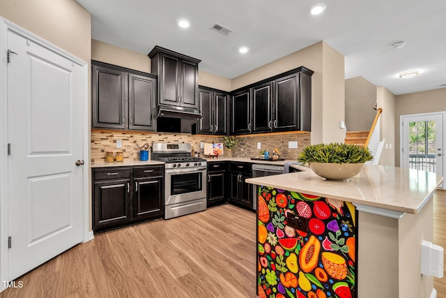 401 Summit Trail Dr, Hillsborough, NC 27278 - kitchen with stainless steel range with gas cooktop, dark cabinets, under cabinet range hood, light wood-style flooring, and recessed lighting