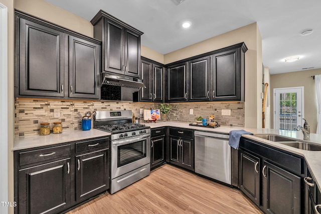 401 Summit Trail Dr, Hillsborough, NC 27278 - kitchen featuring appliances with stainless steel finishes, dark cabinets, extractor fan, light countertops, and decorative backsplash