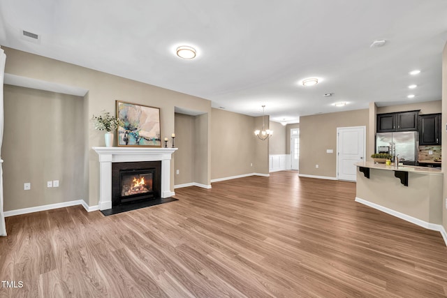 401 Summit Trail Dr, Hillsborough, NC 27278 - unfurnished living room featuring light wood-style floors, a chandelier, a fireplace with flush hearth, and recessed lighting