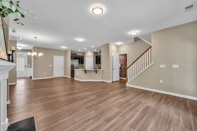 401 Summit Trail Dr, Hillsborough, NC 27278 - unfurnished living room with a chandelier, light wood-type flooring, and stairway