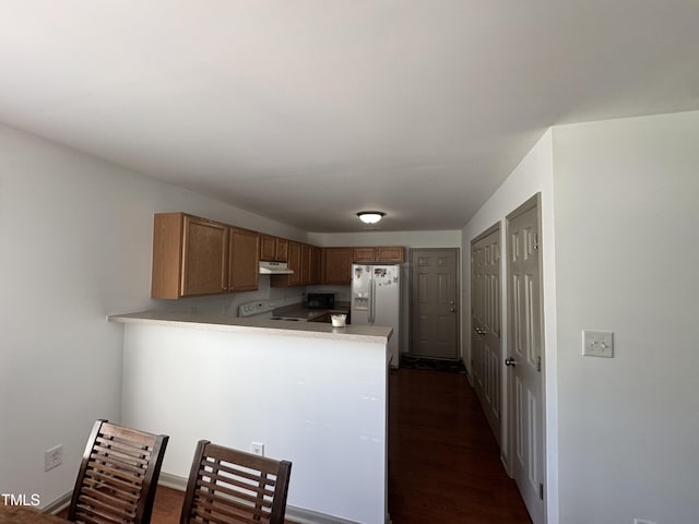 2907 S S Roxboro St, Durham, NC 27707 - kitchen featuring white appliances, light countertops, a peninsula, under cabinet range hood, and dark wood-style floors