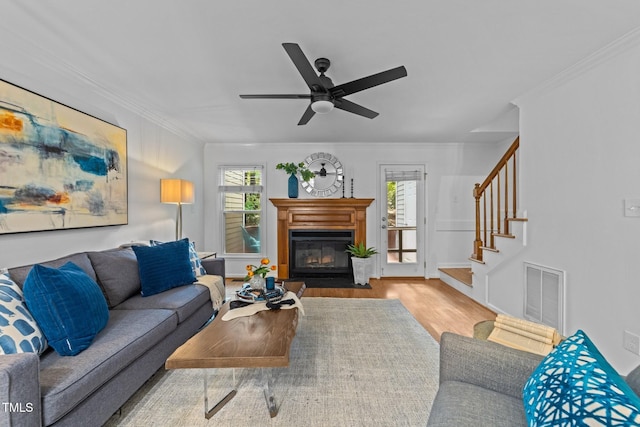 1035 High Lake Ct, Raleigh, NC 27606 - living room with wood finished floors, healthy amount of natural light, crown molding, stairs, and a fireplace with flush hearth