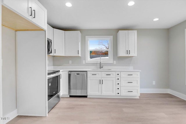 104 N Slocumb St, Goldsboro, NC 27530 - kitchen with appliances with stainless steel finishes, white cabinets, light countertops, light wood-style floors, and recessed lighting