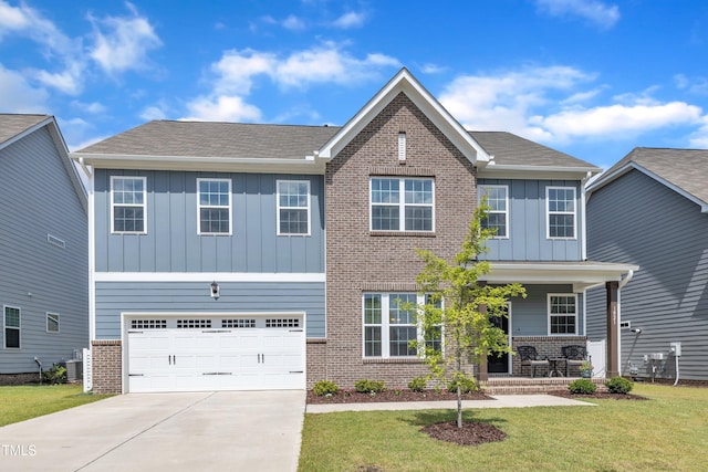 1021 Clove Pine Dr, Knightdale, NC 27545 - view of front facade featuring board and batten siding, brick siding, a porch, and driveway
