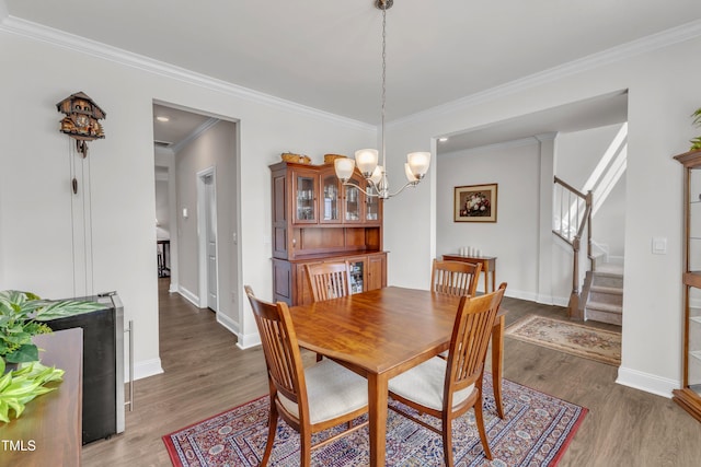 1021 Clove Pine Dr, Knightdale, NC 27545 - dining space featuring a chandelier, wood finished floors, stairs, and ornamental molding