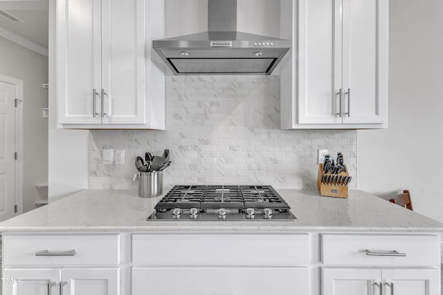 1021 Clove Pine Dr, Knightdale, NC 27545 - kitchen with wall chimney range hood, stainless steel gas stovetop, white cabinets, tasteful backsplash, and crown molding