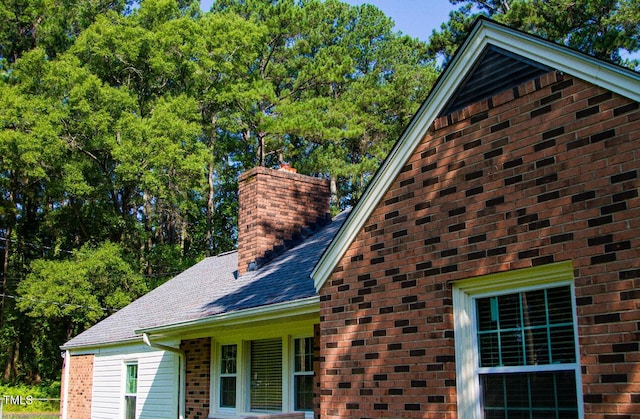 2001 Thomas Ln, Henderson, NC 27536 - exterior view of a chimney, brick siding, gutters, a shingled roof, and a downspout
