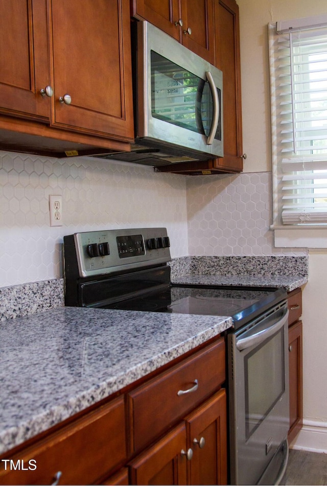 2001 Thomas Ln, Henderson, NC 27536 - kitchen with stainless steel appliances, backsplash, and light stone counters