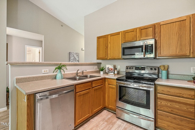 3050 Trailwood Pines Ln Unit 303, Raleigh, NC 27603 - kitchen with appliances with stainless steel finishes, a peninsula, light wood-style flooring, light countertops, and brown cabinets