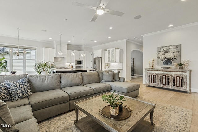 2098 Amalfi Pl, Apex, NC 27502 - living room featuring arched walkways, ornamental molding, recessed lighting, ceiling fan, and light wood-style flooring