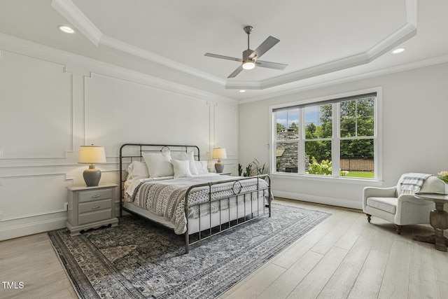 2098 Amalfi Pl, Apex, NC 27502 - bedroom with a tray ceiling, light wood-style flooring, crown molding, ceiling fan, and recessed lighting