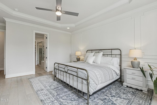 2098 Amalfi Pl, Apex, NC 27502 - bedroom featuring a tray ceiling, light wood-style floors, ornamental molding, a ceiling fan, and ensuite bathroom
