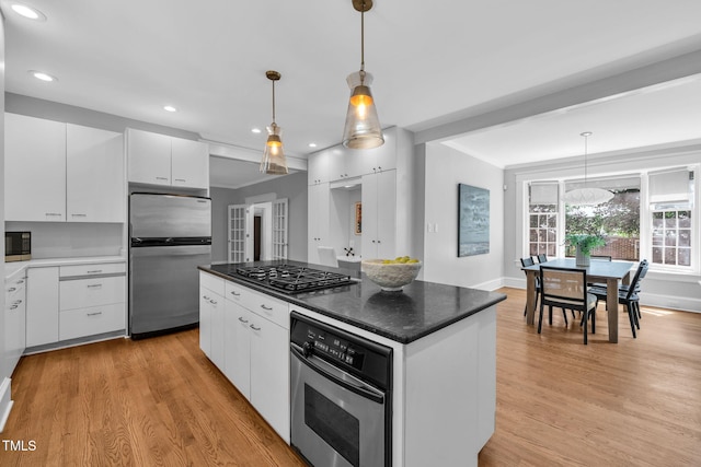 1015 W Trinity Ave, Durham, NC 27701 - kitchen with appliances with stainless steel finishes, light wood-style flooring, white cabinets, recessed lighting, and hanging light fixtures