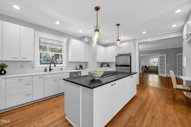 1015 W Trinity Ave, Durham, NC 27701 - kitchen with plenty of natural light, white cabinets, a center island, hanging light fixtures, and recessed lighting