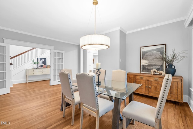 1015 W Trinity Ave, Durham, NC 27701 - dining area featuring light wood-style floors, crown molding, french doors, and stairs