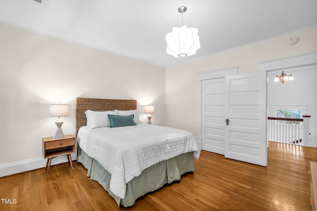 1015 W Trinity Ave, Durham, NC 27701 - bedroom featuring a chandelier, wood finished floors, and ornamental molding