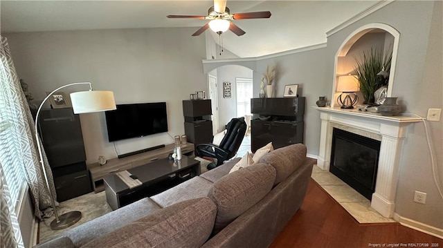 2133 Coinjock Cir, Fayetteville, NC 28304 - living room with ceiling fan, a tiled fireplace, vaulted ceiling, and light wood-style flooring