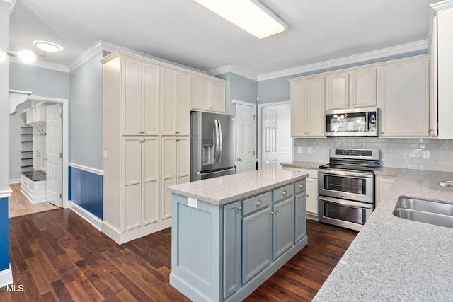 614 Park York Ln, Cary, NC 27519 - kitchen featuring appliances with stainless steel finishes, crown molding, dark wood-type flooring, tasteful backsplash, and a kitchen island