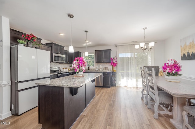 1405 Currituck Ave, Dunn, NC 28334 - kitchen with appliances with stainless steel finishes, a chandelier, light wood finished floors, tasteful backsplash, and recessed lighting