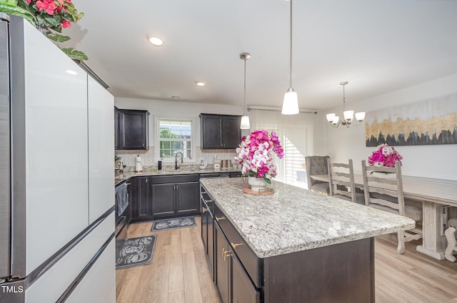 1405 Currituck Ave, Dunn, NC 28334 - kitchen featuring freestanding refrigerator, light wood-type flooring, a kitchen island, a chandelier, and recessed lighting