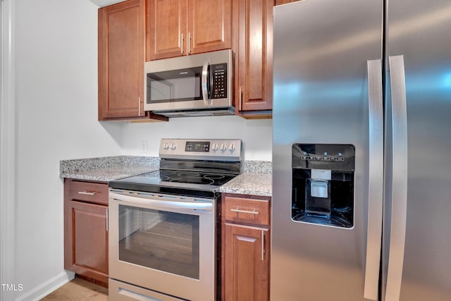 1804 Charles St, Raleigh, NC 27610 - kitchen with stainless steel appliances, light stone countertops, and brown cabinets
