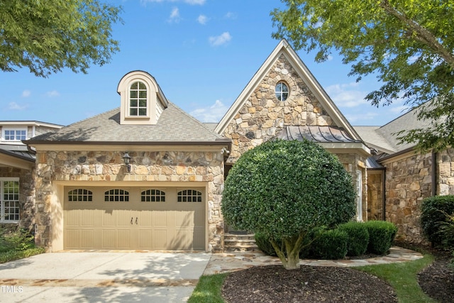 4137 Gardenlake Dr, Raleigh, NC 27612 - french provincial home with stone siding, a standing seam roof, concrete driveway, an attached garage, and a metal roof