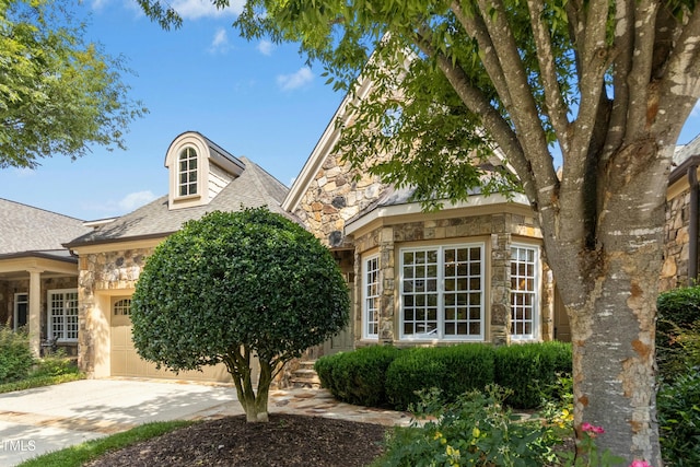4137 Gardenlake Dr, Raleigh, NC 27612 - view of front of property featuring stone siding, an attached garage, driveway, and a shingled roof