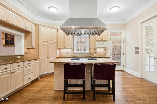 4137 Gardenlake Dr, Raleigh, NC 27612 - kitchen featuring island exhaust hood, white microwave, tasteful backsplash, light wood-style floors, and crown molding