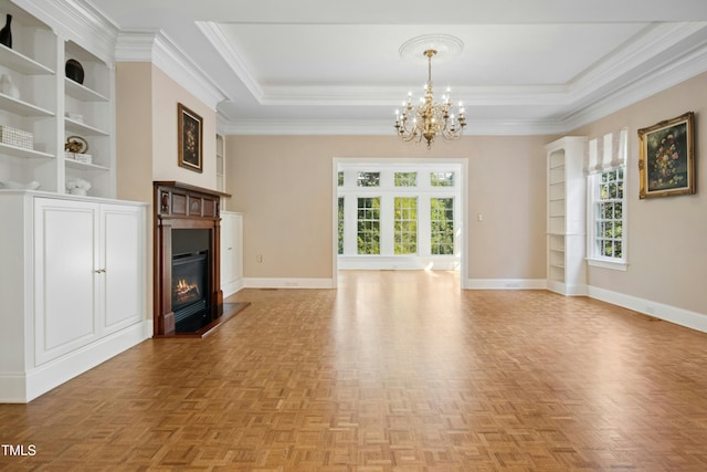 4137 Gardenlake Dr, Raleigh, NC 27612 - unfurnished living room with a chandelier, crown molding, a glass covered fireplace, a raised ceiling, and built in shelves