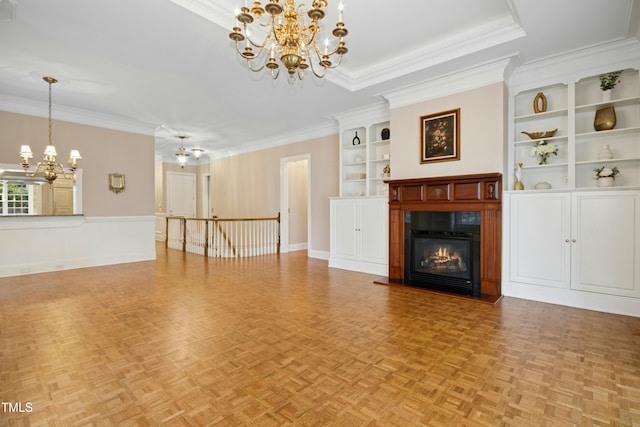 4137 Gardenlake Dr, Raleigh, NC 27612 - unfurnished living room featuring a chandelier, a glass covered fireplace, crown molding, and built in features
