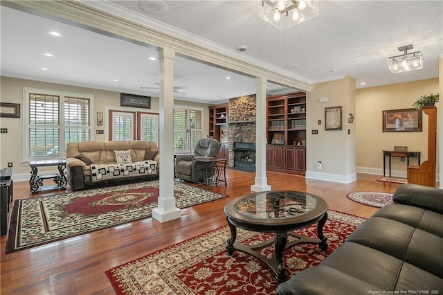 9871 Ramsey St, Linden, NC 28356 - living area with ornate columns, built in shelves, wood finished floors, a fireplace, and ornamental molding