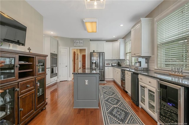 9871 Ramsey St, Linden, NC 28356 - kitchen with beverage cooler, stainless steel appliances, a center island, decorative backsplash, and white cabinets