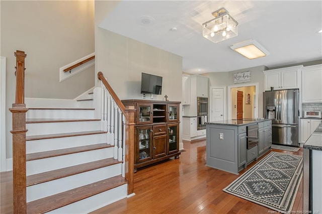 9871 Ramsey St, Linden, NC 28356 - kitchen with stainless steel appliances, gray cabinetry, a kitchen island, white cabinetry, and wood-type flooring
