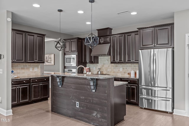 113 Willow View Ln, Apex, NC 27539 - kitchen featuring stainless steel appliances, under cabinet range hood, light wood-type flooring, a kitchen island with sink, and recessed lighting