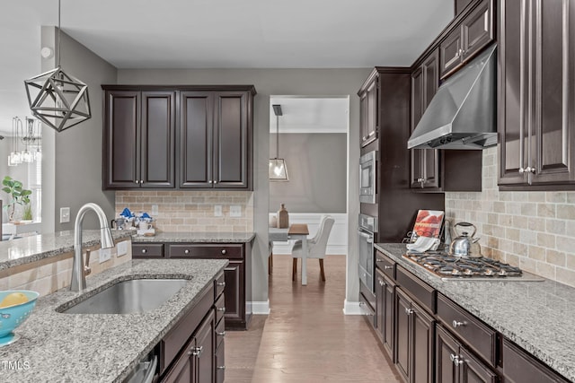 113 Willow View Ln, Apex, NC 27539 - kitchen with under cabinet range hood, stainless steel appliances, dark brown cabinets, light stone counters, and light wood-style flooring