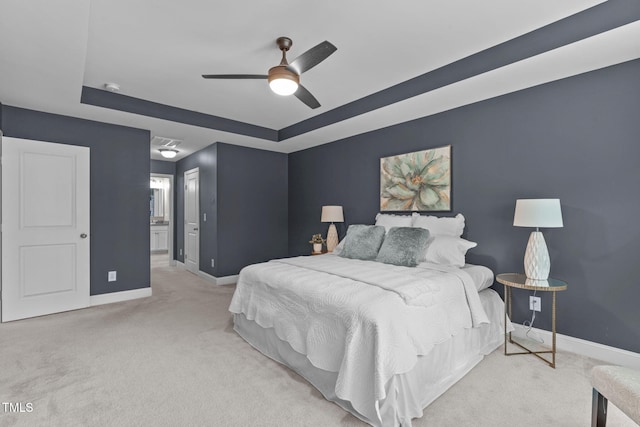 113 Willow View Ln, Apex, NC 27539 - carpeted bedroom with a tray ceiling, connected bathroom, and ceiling fan