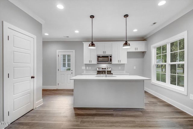 1307 S 14th St, Lillington, NC 27546 - kitchen with appliances with stainless steel finishes, white cabinetry, light countertops, a center island with sink, and pendant lighting