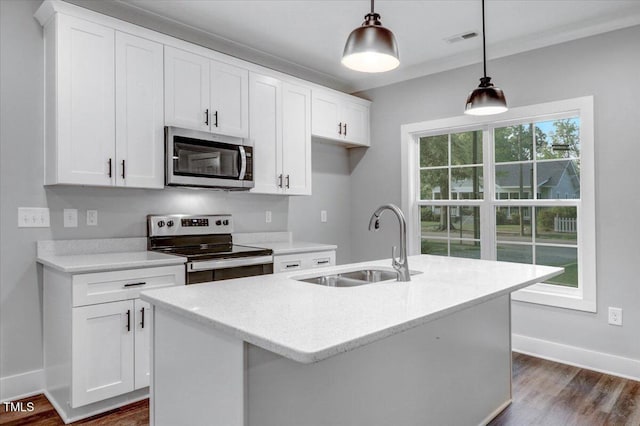 1307 S 14th St, Lillington, NC 27546 - kitchen with stainless steel appliances, an island with sink, white cabinetry, and dark wood-style floors