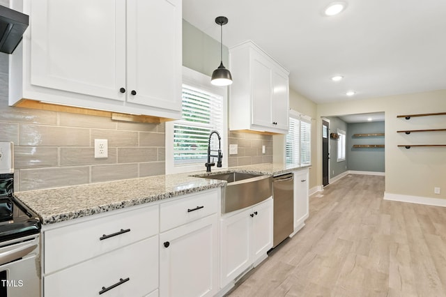 7722 NC-27, Lillington, NC 27546 - kitchen featuring stainless steel appliances, light wood finished floors, white cabinetry, wall chimney exhaust hood, and backsplash
