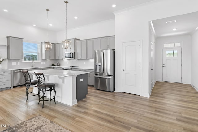 6109 Oak Passage Dr, Raleigh, NC 27603 - kitchen featuring appliances with stainless steel finishes, gray cabinetry, a breakfast bar area, and recessed lighting
