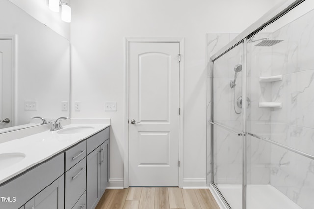 6109 Oak Passage Dr, Raleigh, NC 27603 - bathroom featuring a marble finish shower, double vanity, and wood finished floors