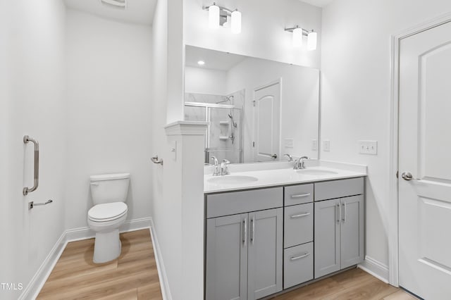 6109 Oak Passage Dr, Raleigh, NC 27603 - bathroom with double vanity, wood finished floors, and a shower with door