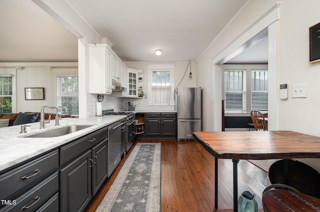 513 Cutler St, Raleigh, NC 27603 - kitchen featuring appliances with stainless steel finishes, white cabinetry, dark wood finished floors, exhaust hood, and decorative backsplash