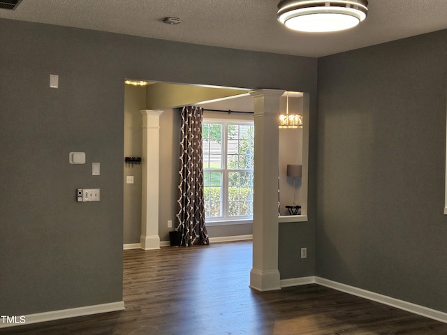 121 Brentfield Loop, Morrisville, NC 27560 - empty room with ornate columns, dark wood-style flooring, a smoke detector, and a textured ceiling