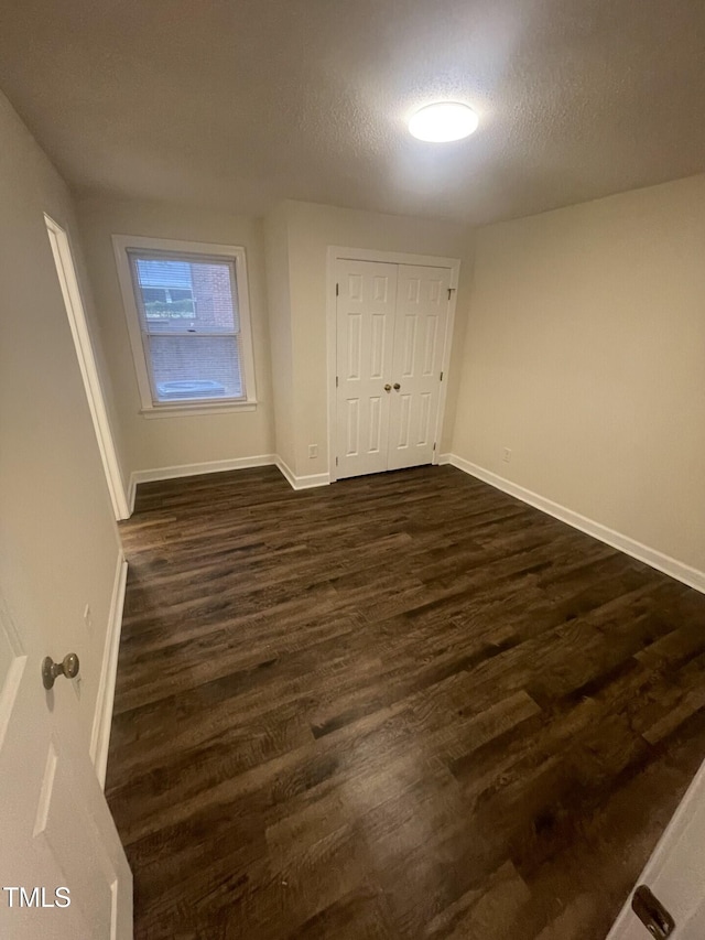 3603 Helix Ct Unit 102, Raleigh, NC 27606 - unfurnished bedroom with dark wood finished floors, a closet, and a textured ceiling