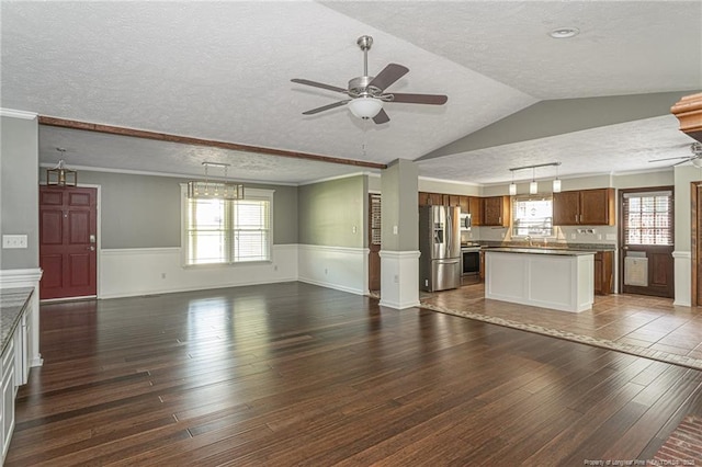 5621 Monks Walk Ct, Fayetteville, NC 28311 - unfurnished living room featuring wood-type flooring, ceiling fan, wainscoting, a textured ceiling, and plenty of natural light