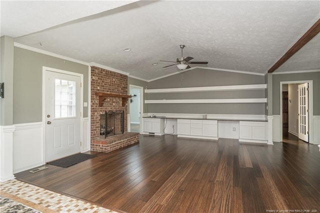 5621 Monks Walk Ct, Fayetteville, NC 28311 - unfurnished living room with ceiling fan, dark wood-style floors, a brick fireplace, wainscoting, and lofted ceiling