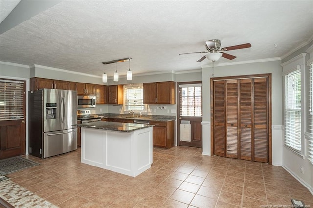 5621 Monks Walk Ct, Fayetteville, NC 28311 - kitchen featuring stainless steel appliances, a ceiling fan, healthy amount of natural light, brown cabinetry, and crown molding