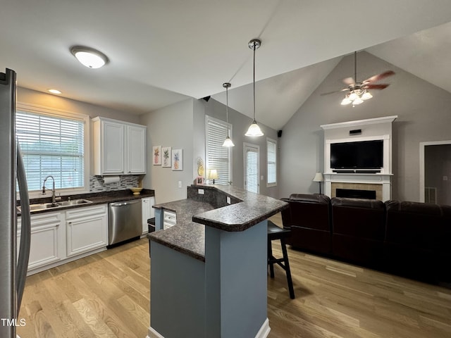 71 Beaver Creek Dr, Dunn, NC 28334 - kitchen featuring stainless steel appliances, a breakfast bar area, light wood finished floors, open floor plan, and lofted ceiling