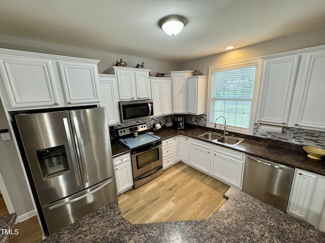 71 Beaver Creek Dr, Dunn, NC 28334 - kitchen featuring appliances with stainless steel finishes, white cabinetry, decorative backsplash, and light wood-style flooring